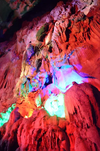 Beautiful illuminated multicolored stalactites from karst Reed Flute cave. Guilin Guangxi China — Stock Photo, Image