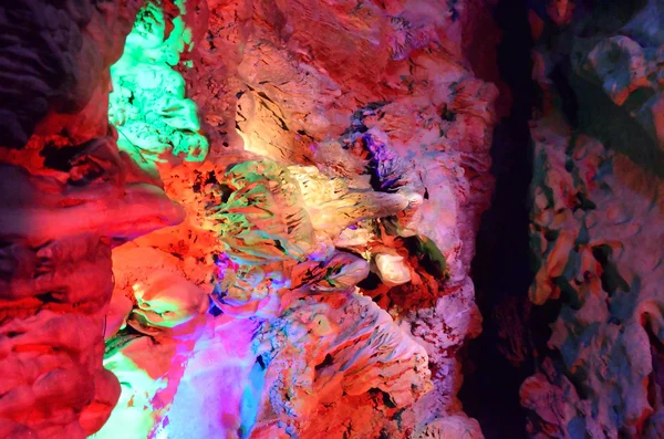 Beautiful illuminated multicolored stalactites from karst Reed Flute cave. Guilin Guangxi China — Stock Photo, Image