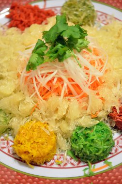 Özel yemek sırasında Çin yeni yılı Yusheng veya Yee Sang adı verilen