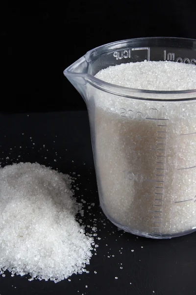 Measuring cup with sugar — Stock Photo, Image