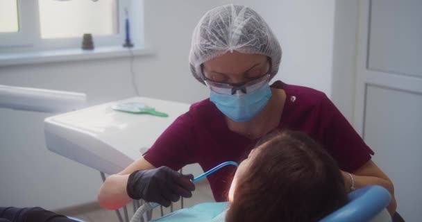 Лечение зуба, стоматолог очищает потерю — стоковое видео