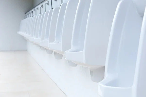 Lijn van witte urinoirs in openbare badkamer, Thailand — Stockfoto