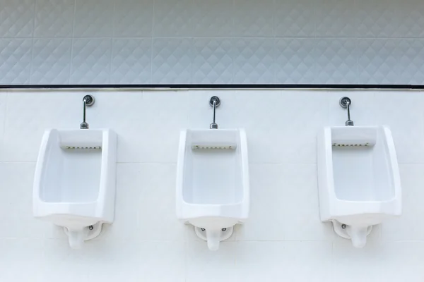 Line of white urinals in public bathroom, Thailand Лицензионные Стоковые Фото