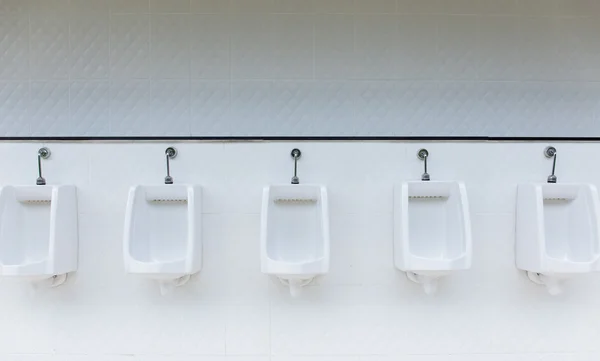 Line of white urinals in public bathroom, Thailand2 Лицензионные Стоковые Изображения