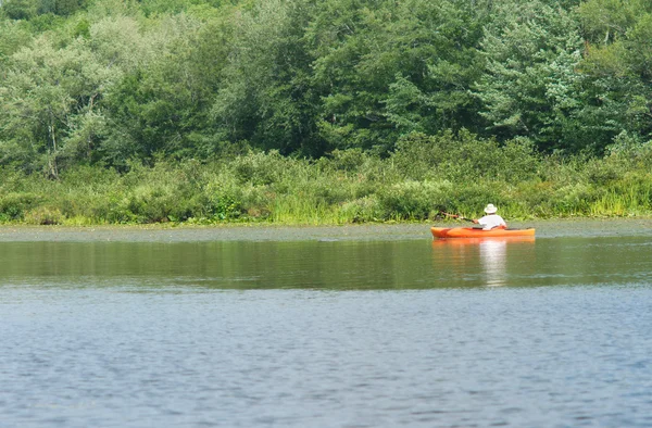 Red orange kayak or canoe on calm lake — Stock Photo, Image