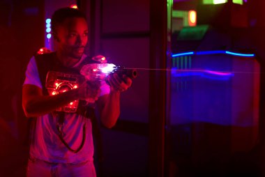 Lazer tag oynatıcı eğlence merkezinde silah tutuyor oyun oynuyor