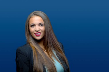 Mavi arka planda kadın portresi. İş kadını. Gülümseyen genç bayan.