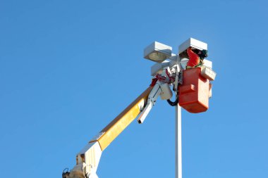 turuncu önlük işçisi sokak lambasını değiştiriyor kiraz toplayıcı asansörü