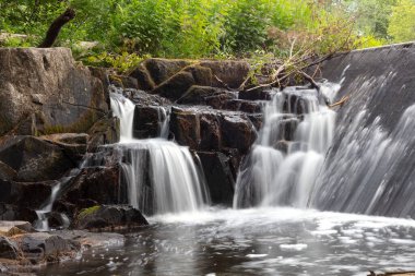 Dağdaki kayalıklarda berrak bir su üzerinde güzel bir şelale.