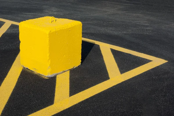 Bloque de hormigón amarillo apuntando líneas asfalto — Foto de Stock