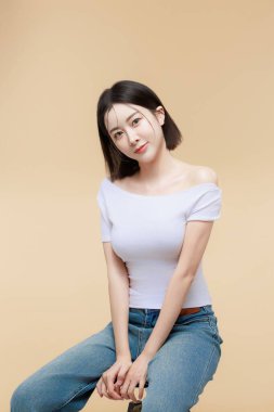 Çeşitli promosyon jestleri olan mutlu Asyalı genç kadın fotokopi alanı. Ürününüzü, manşetinizi ya da önemli bilgilerinizi sunmak için ideal. Neşeli ve ilgi çekici bir reklam konsepti.