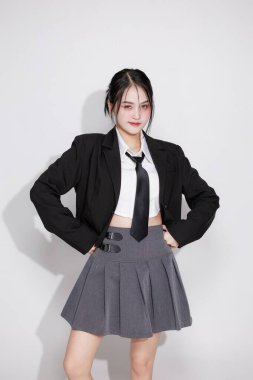 K-Pop idolü gibi titreşen Asyalı bir kadın, siyah ceket ve kravat takıyor. Kore moda trendleri, müzik videoları veya eğlence içeriği konsepti.