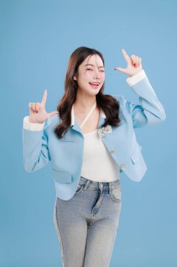 Boş fotokopi alanını gösteren mutlu bir Asyalı kadının portresi. Metin, afiş ve reklam eklemek için ideal. Mavide izole edilmiş. Pazarlama kampanyaları ve reklam pankartları.