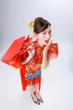 Asyalı zengin kadın şanslı para ve alışveriş torbalarıyla Ay 'ın yeni yılını kutluyor. Çin Yeni Yıl alışveriş çılgınlığı için konsept, şanslı para harcamak ve hediyeler almak.