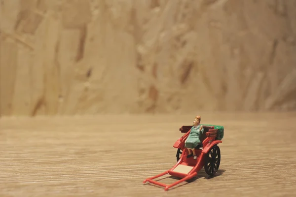 Estátua em miniatura e vermelho vintage oriental rickshaw táxi — Fotografia de Stock