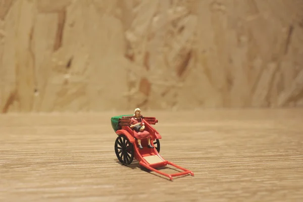 Estátua em miniatura e vermelho vintage oriental rickshaw táxi — Fotografia de Stock