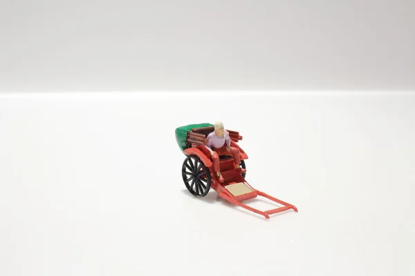 Miniature statue and red vintage oriental rickshaw cab — Stock Photo, Image