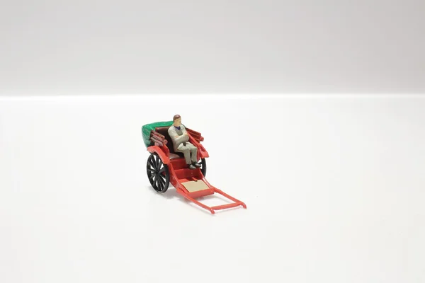 Miniatura estatua y rojo vintage oriental rickshaw taxi — Foto de Stock