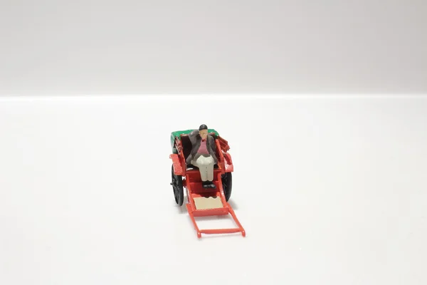 Estátua em miniatura e vermelho vintage oriental rickshaw táxi — Fotografia de Stock