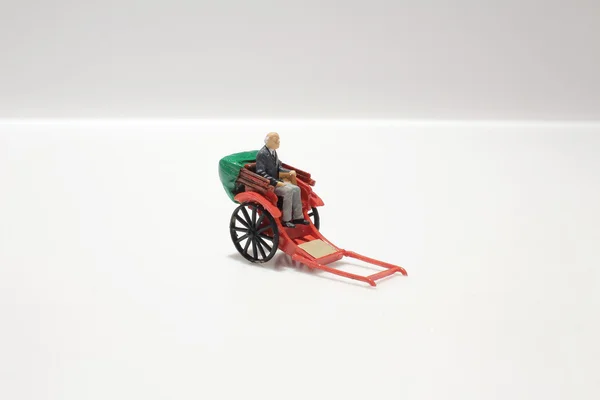 Miniature statue and red vintage oriental rickshaw cab — Stock Photo, Image