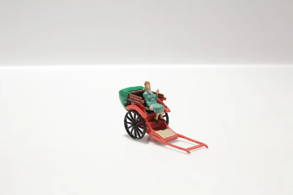 Estátua em miniatura e vermelho vintage oriental rickshaw táxi — Fotografia de Stock