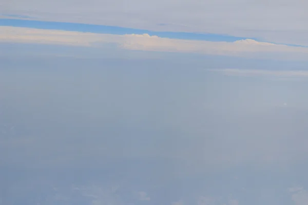 Vista dal finestrino di un aereo che vola tra le nuvole — Foto Stock