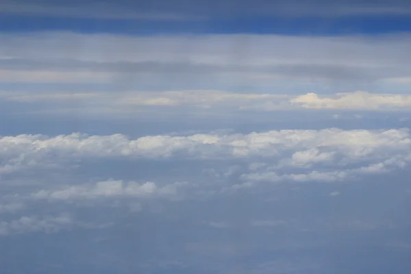 Vista dal finestrino di un aereo che vola tra le nuvole — Foto Stock