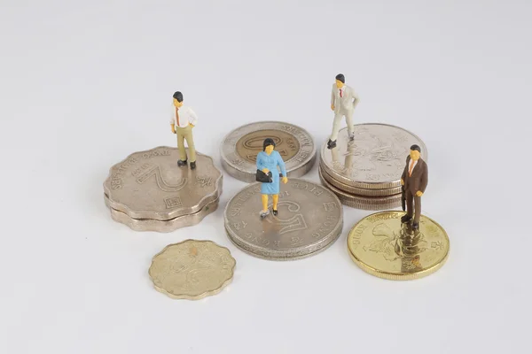 Hombres en miniatura se sientan en monedas —  Fotos de Stock