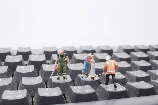 a mini people cleaning the keyboard Or calculator