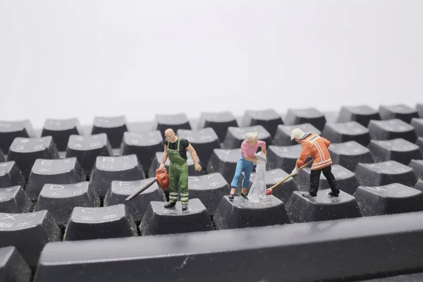 a mini people cleaning the keyboard Or calculator