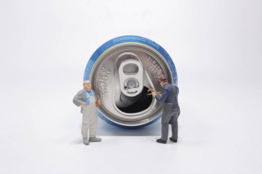 Teneke kutuyu açmaya çalışan figürlü bir işçi..