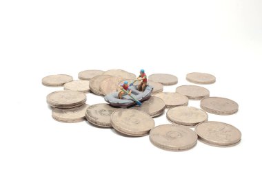 Bozuk paraların üzerinde kürek çeken gezginler. Etkinlikler için resim kullanımı, seyahat iş konsepti.