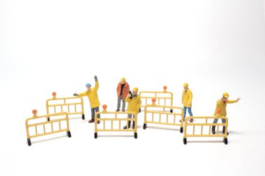 Beton sokakta yol tahtası olan mini bir figür.