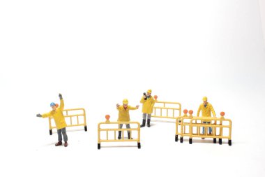 Beton sokakta yol tahtası olan mini bir figür.