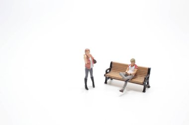 Erkek figürü, kız arkadaşı beklerken mobil ekrana bakar.