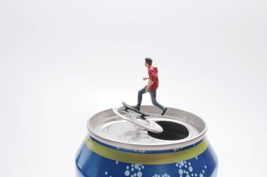 Mini figür kaykayı konserve kutusunda çalıyor.