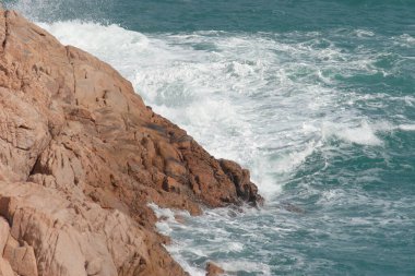 Büyük dalgalar ve fırtınalı denizde karanlık kayalar Po Toi Adaları