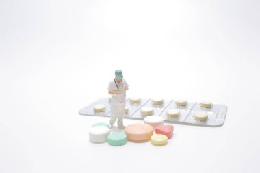 Tıbbi hap ve doktorun küçük ölçeği.