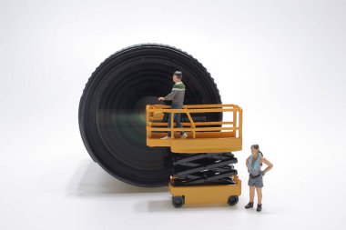 Mini bakım figürü dijital kameranın lens kısmına yerleştirildi.