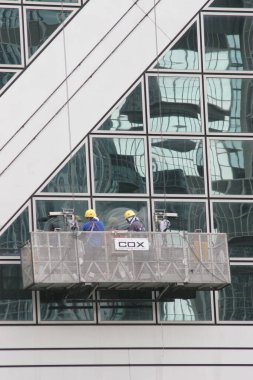 25 Haziran 2005 'te modern binanın camlarını yıkayan işçilerin portresi.