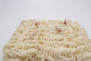 Mini figürün eğlencesi erişte üzerinde yüzüyor.