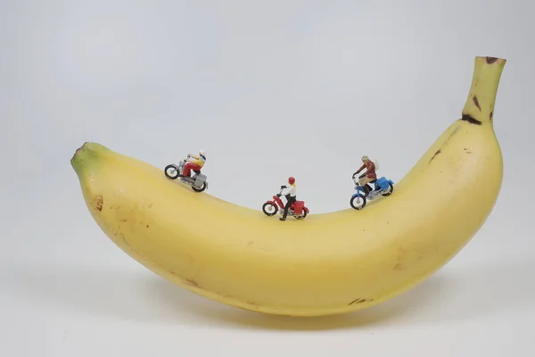 mini figure ride motorbike race on a banana