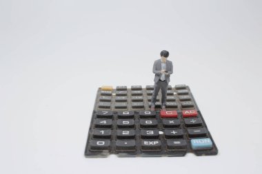 İş ve teknoloji kavramı. Klavyede duran iş adamı minyatür figürler