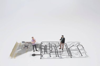 İş ve teknoloji kavramı. Bütünleşik Devrelerde duran iki işadamı minyatür figürü