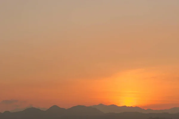 オレンジ色の空に銀の裏地と雲が立ち並ぶ強い日の出の風景 — ストック写真