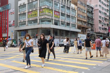 5 Haziran 2021 'de Mong Kok' ta karşıdan karşıya geçerken koruyucu maskeler takıyorlar.