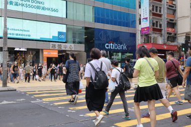 5 Haziran 2021 'de Mong Kok' ta karşıdan karşıya geçerken koruyucu maskeler takıyorlar.