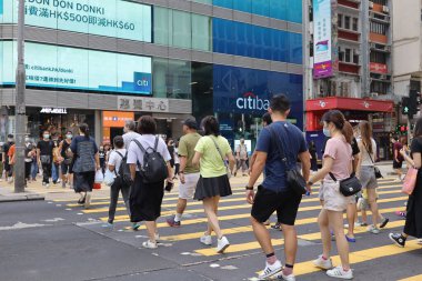 5 Haziran 2021 'de Mong Kok' ta karşıdan karşıya geçerken koruyucu maskeler takıyorlar.