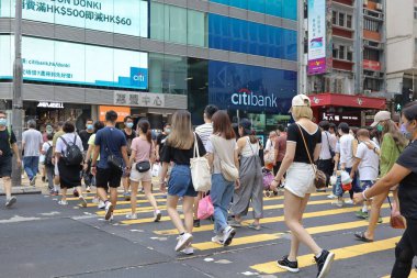 5 Haziran 2021 'de Mong Kok' ta karşıdan karşıya geçerken koruyucu maskeler takıyorlar.