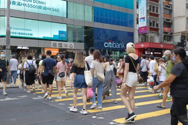 5 Haziran 2021 'de Mong Kok' ta karşıdan karşıya geçerken koruyucu maskeler takıyorlar.